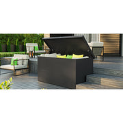 A Telluria Nevio storage box on a decked terrace with the lid open and seat cushions stacked inside, garden furniture alongside