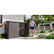 A Telluria Velotto beside a house with the bi-folding doors folded back and a bike inside, showing how the store sits against a wall in a side passage
