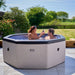 Wave Como 6 Person hot tub in pebble white, lifestyle setting with people