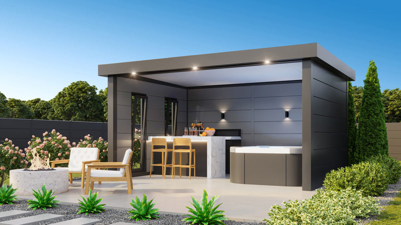 Telluria Singolo 4836 garden lounge in anthracite, the open front sheltering an outdoor kitchen, bar stools and lounge seating, with the eaves and rear wall lit at dusk