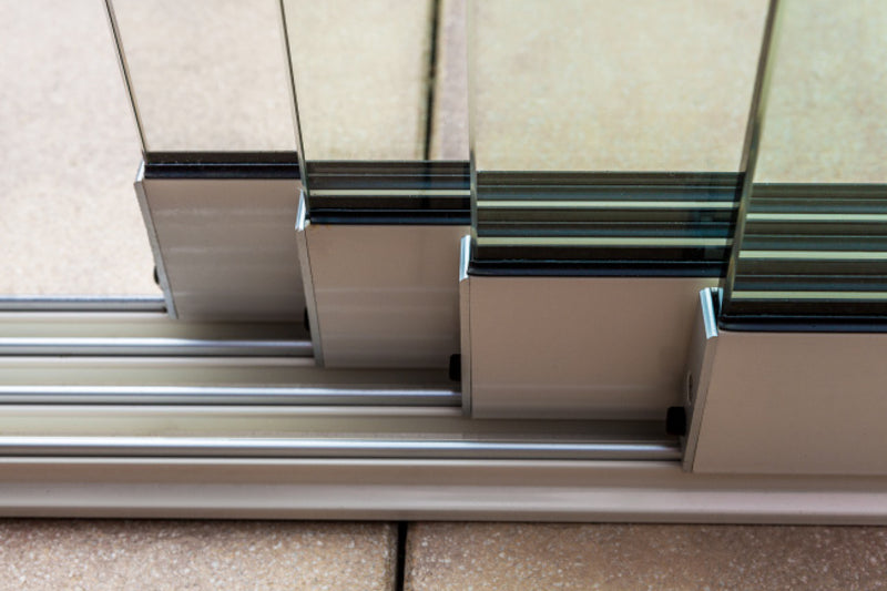 The floor track supplied with the Telluria sliding doors, set flush into the paving with the glass panels seated in it, so there is no step to trip over across the opening