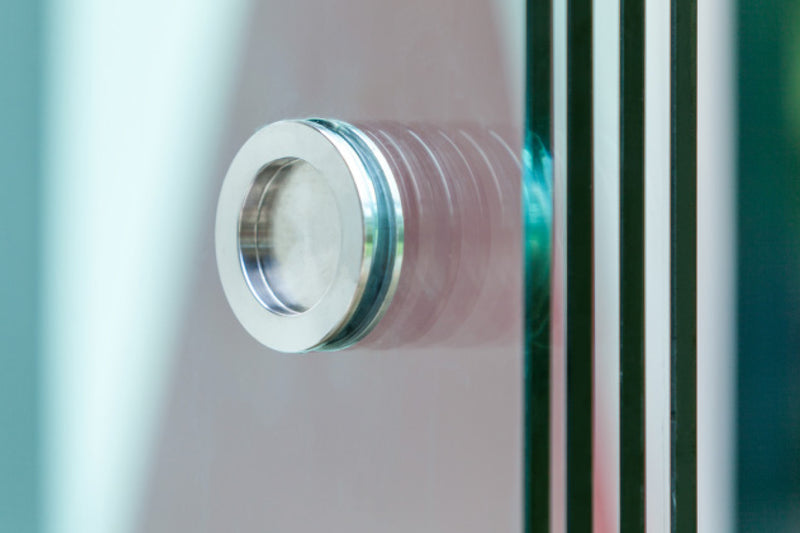Round stainless steel handle fitted through a Telluria sliding door panel, one of the parts included in the sliding door price