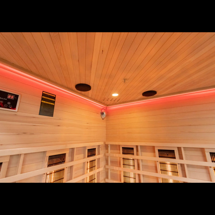 Infrared corner sauna with wooden walls and control panel.