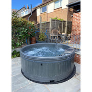RotoSpa QuatroSpa 6 person hot tub in use on a patio