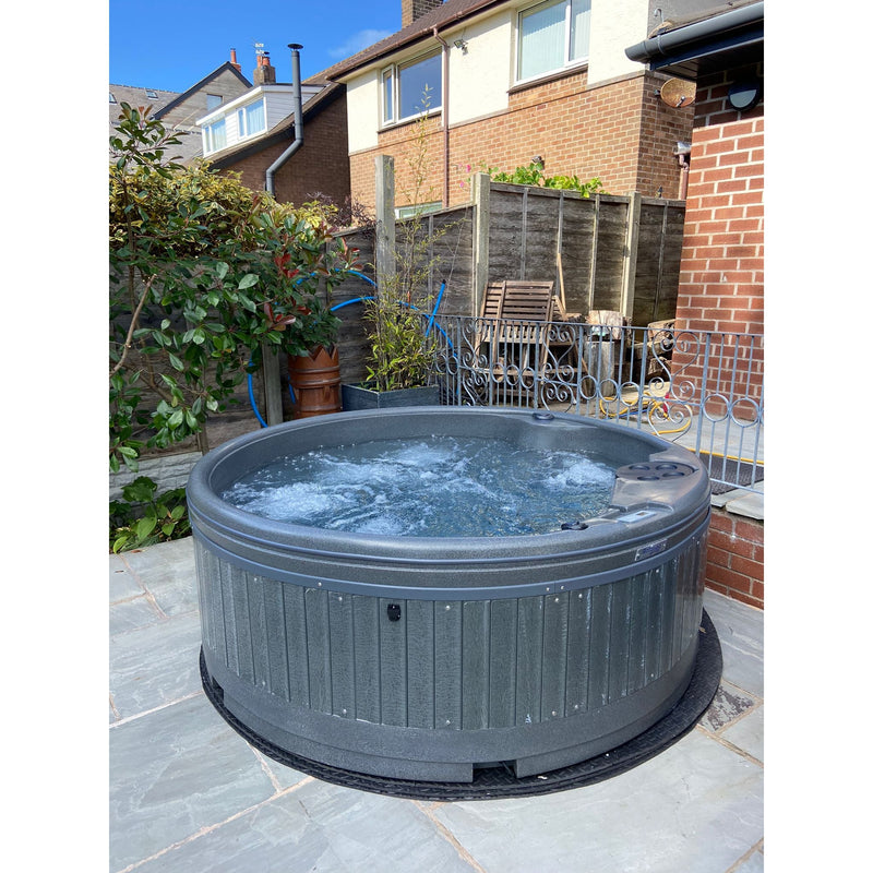 RotoSpa QuatroSpa 6 person hot tub in use on a patio