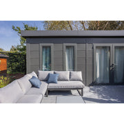 Telluria Luminato 5436 Plus steel garden room installed as a home office, double doors and full-height windows across the front, with an outdoor sofa on the terrace in front of it