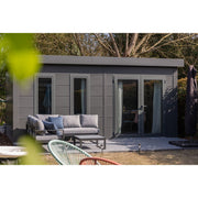 Telluria Luminato 5436 Plus garden room seen from across the garden, showing the full 5.4m length, the flat roof and the run of full-height glazing, with garden furniture and planting alongside